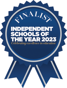 A blue rosette badge with FINALIST Independent Schools of the Year 2023 – Celebrating excellence in education for St Andrews Prep Boarding, written in white and gold text.